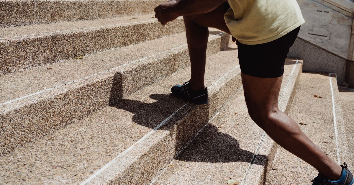 A man running up stone stairs outdoors, showcasing fitness and urban exercise.