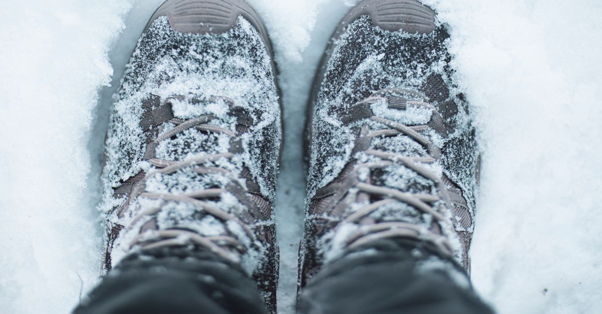 Close-up of snow-covered hiking shoes in a winter scene, capturing the essence of outdoor adventures.
