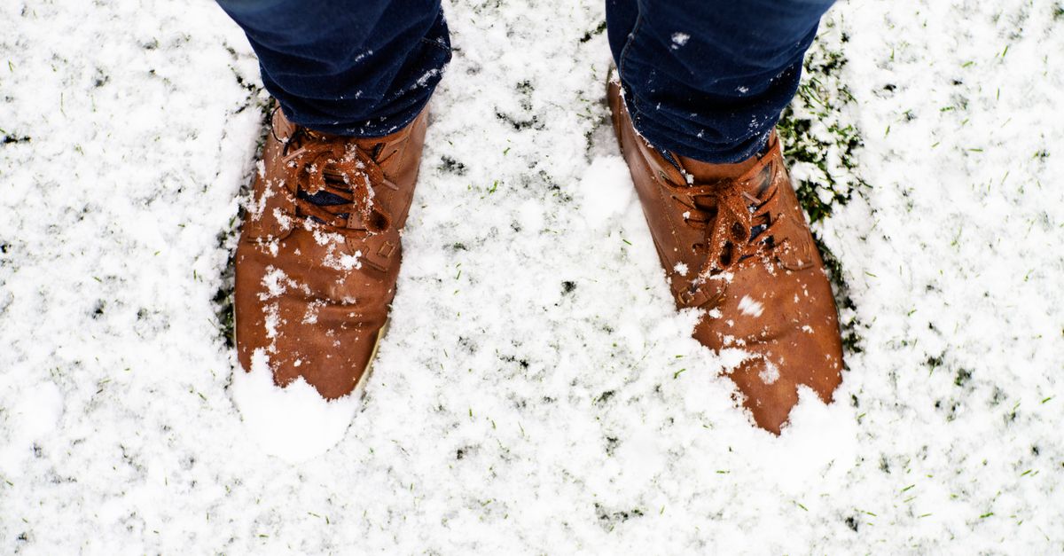 Brown shoes in snow during winter in Wyoming, USA, emphasizing winter fashion and outdoor exploration.