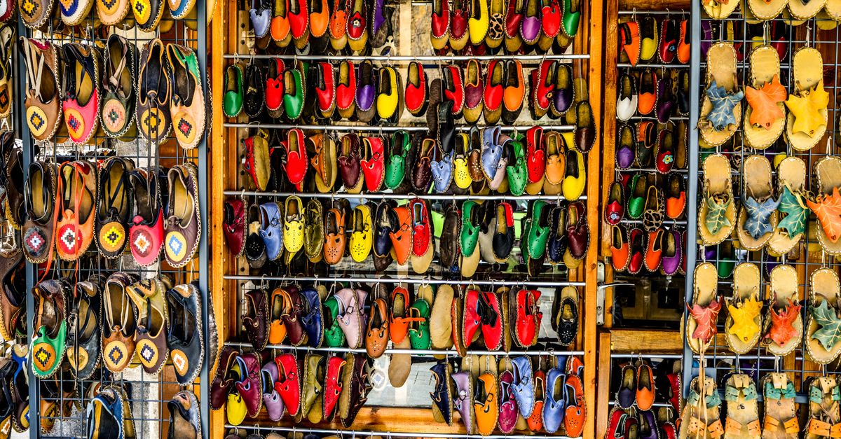 Vibrant assortment of traditional shoes displayed at an outdoor market stall.