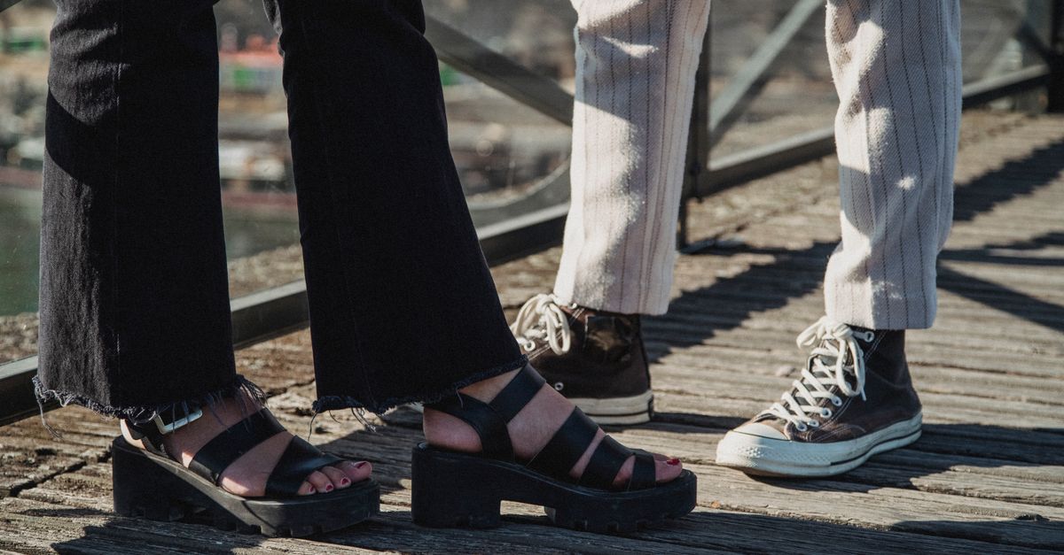 Stylish footwear on display outdoors, showcasing sandals and sneakers in a casual setting.