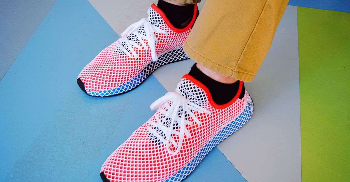 Close-up of vibrant sneakers on a geometric pattern floor.